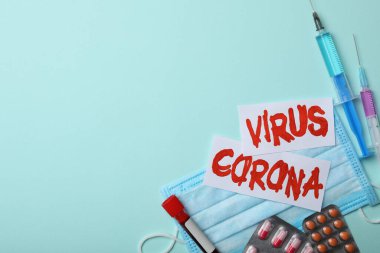Düz kompozisyonda Corona virüsü ve açık mavi arka planda ilaçlar vardı. Metin için boşluk