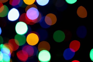 Siyah arkaplandaki renkli ışıkların bulanık görüntüsü. Bokeh etkisi
