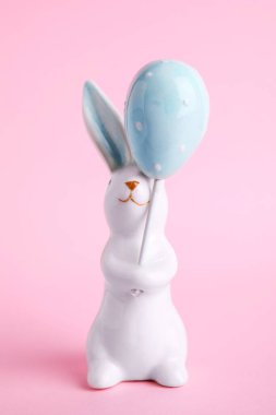 Pembe arka planda Paskalya dekoru olarak tavşan seramik figürü