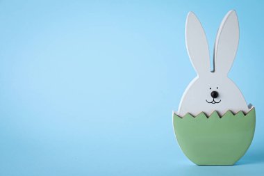 Açık mavi arka planda Paskalya tavşanı figürü. Metin için boşluk