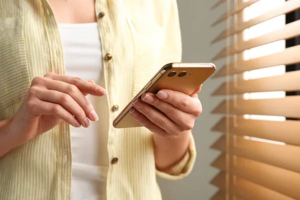 Jovem Mulher Usando Smartphone Moderno Perto Janela Dentro Casa Close — Fotografia de Stock