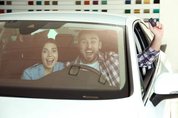 Casal Feliz Com Chave Carro Sentado Automóvel Moderno Concessionária — Fotografia de Stock