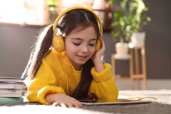 Χαριτωμένο Κοριτσάκι Ακουστικά Και Tablet Ακούγοντας Audiobook Στο Σπίτι — Φωτογραφία Αρχείου