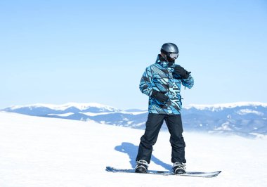Dağlardaki karlı yamaçta erkek snowboardcu. Kış tatili