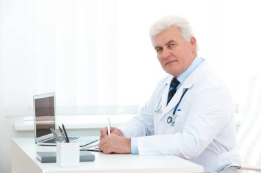 İş yerinde beyaz önlüklü kıdemli doktorun portresi.