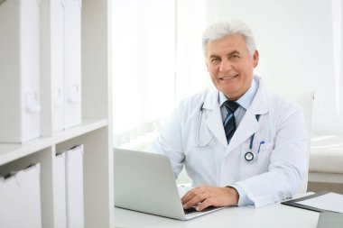 İş yerinde beyaz önlüklü kıdemli doktorun portresi.