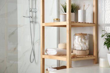 Banyo içinde tuvalet malzemeleri olan raf ünitesi.