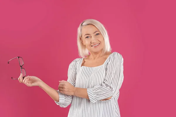 Retrato Una Hermosa Mujer Madura Con Gafas Sobre Fondo Rosa —  Fotos de Stock