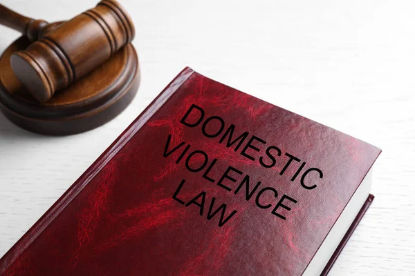 家庭内暴力法と白い木製のテーブルの上に砂利 クローズアップ — ストック写真