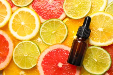 Turunçgil dilimleri üzerine bir şişe temel yağ, düzlük. Metin için boşluk