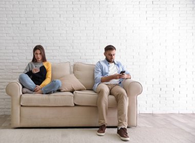 Evde birbirini görmezden gelen akıllı telefonlara bağımlı bir çift. İlişki sorunları