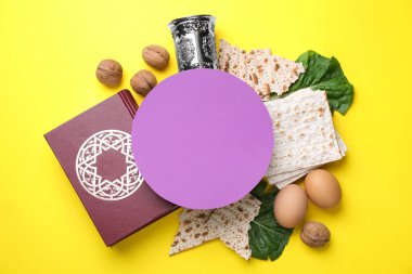 Sembolik Hamursuz Bayramı öğeleriyle yapılmış çerçeve ve sarı arkaplanda boş kart, metin için boşluk. Pesah kutlaması