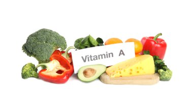 Beyaz zemin üzerinde VITAMIN A yazılı farklı doğal besin ve kağıt