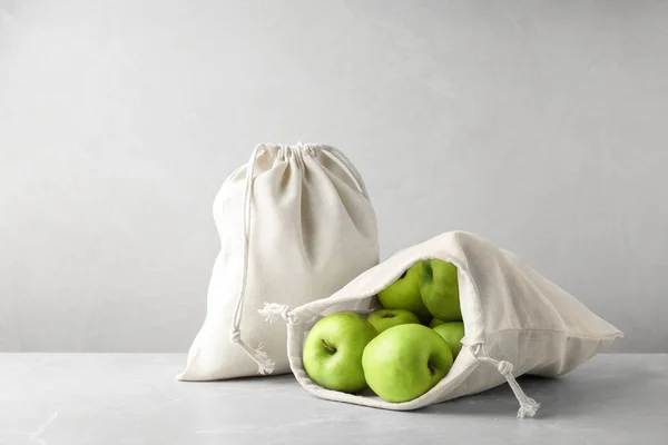 Cotton eco bags with apples on marble table