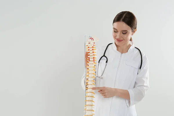 Ortopedista Feminina Com Modelo Coluna Vertebral Humana Contra Fundo Claro — Fotografia de Stock