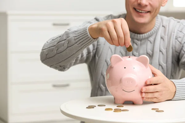 Hombre Poniendo Moneda Alcancía Mesa Blanca Interior Primer Plano —  Fotos de Stock