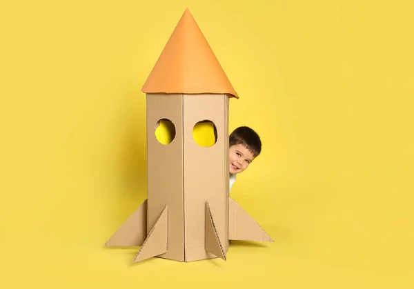 Lindo Niño Jugando Con Cohete Cartón Sobre Fondo Amarillo —  Fotos de Stock