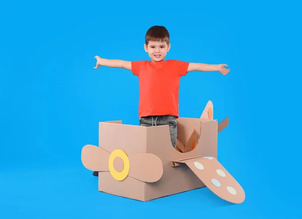 Lindo Niño Pequeño Jugando Con Avión Cartón Sobre Fondo Azul — Foto de Stock