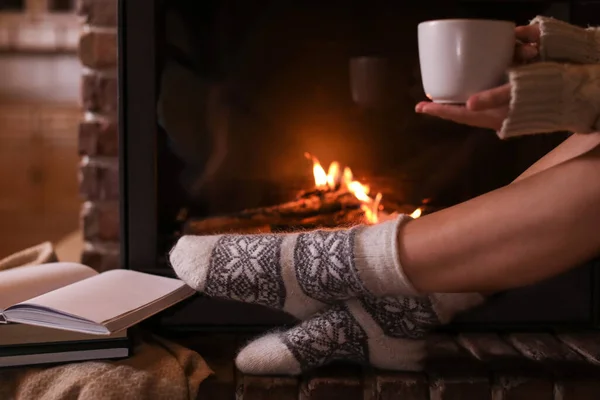 暖炉の近くにホットココアのカップを持つ女性 クローズアップ — ストック写真
