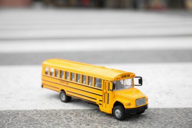 Açık hava yolundaki sarı oyuncak okul otobüsü. Öğrenciler için taşıma