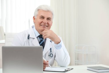 İş yerinde beyaz önlüklü kıdemli doktorun portresi.