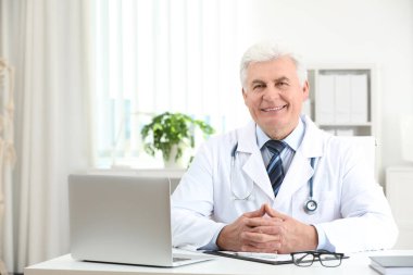 İş yerinde beyaz önlüklü kıdemli doktorun portresi.