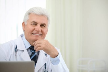 İş yerinde beyaz önlüklü kıdemli doktorun portresi.
