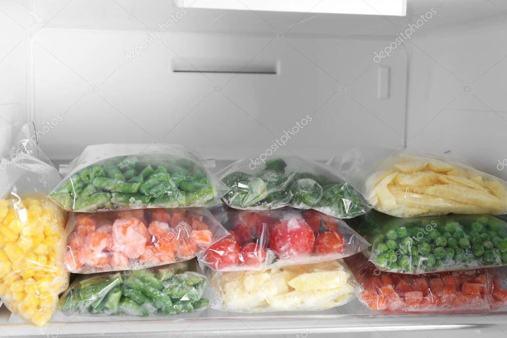 Bolsas de plástico con diferentes verduras congeladas en nevera 2024