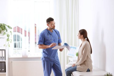 Hastanedeki muayenehanesinde doktora danışıyorum.