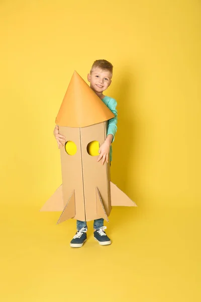 Małe Dziecko Bawiące Się Rakietą Kartonowego Pudełka Żółtym Tle — Zdjęcie stockowe