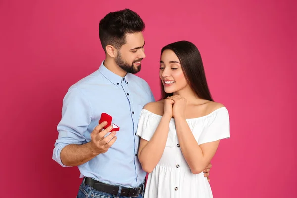Man Med Förlovningsring Gör Giftermål Med Flickvän Crimson Bakgrund — Stockfoto