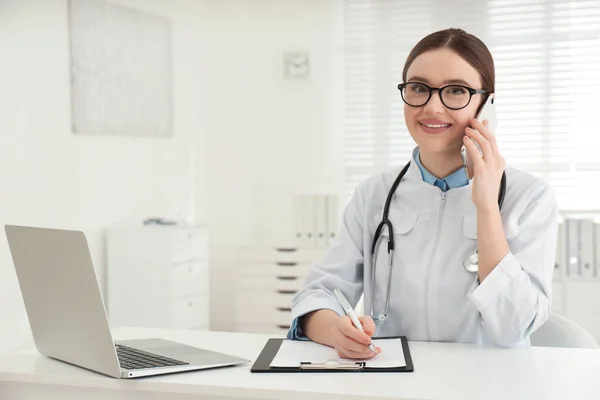 Jovem Médica Falando Telefone Mesa Escritório — Fotografia de Stock