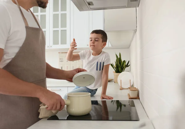 Father and son cooking together in kitchen, closeup