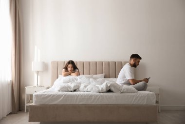 Genç bir adam evde kız arkadaşının yanında akıllı telefonu tercih ediyor. İlişki sorunları