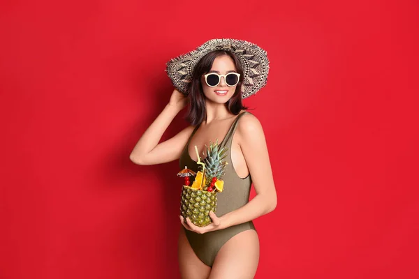 Schöne Frau Eleganten Badeanzug Mit Tropischem Cocktail Auf Rotem Hintergrund — Stockfoto