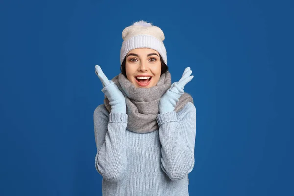 暖かいセーター スカーフ 帽子を青い背景に身に着けている興奮した女性 冬の季節 — ストック写真