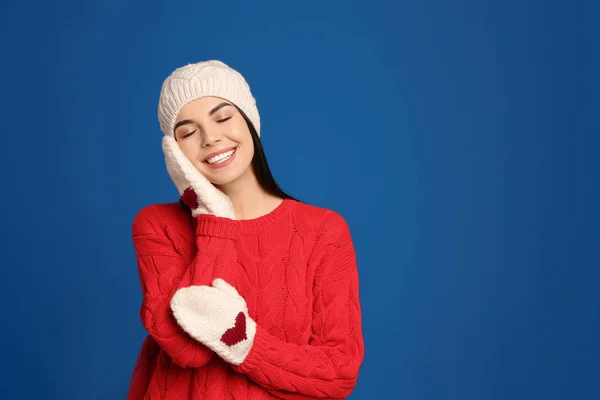 暖かいセーター ミトン 帽子を青い背景に身に着けている若い女性 冬の季節 — ストック写真