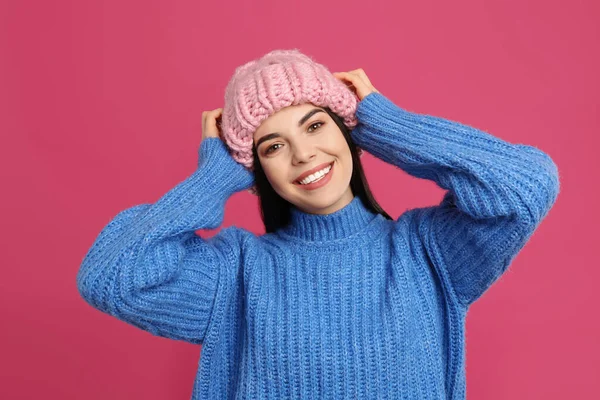 暖かいセーターと帽子を真紅の背景に身に着けている若い女性 冬の季節 — ストック写真