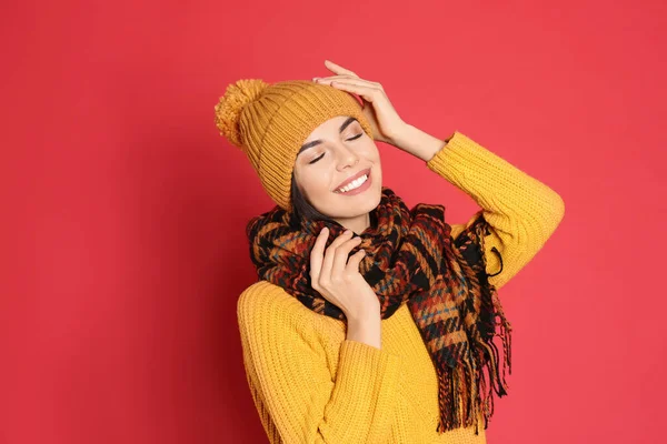 暖かいセーター スカーフ 赤い背景の帽子を身に着けている若い女性 冬の季節 — ストック写真