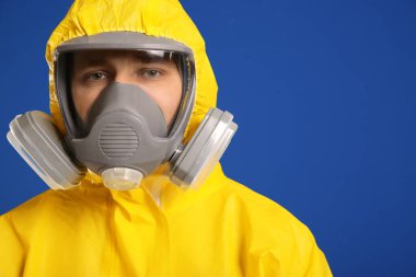 Man wearing chemical protective suit on blue background, closeup. Virus research clipart