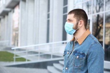 Açık havada tek kullanımlık maske takan bir adam. Tehlikeli bir virüs.