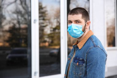 Açık havada tek kullanımlık maske takan bir adam. Tehlikeli bir virüs.