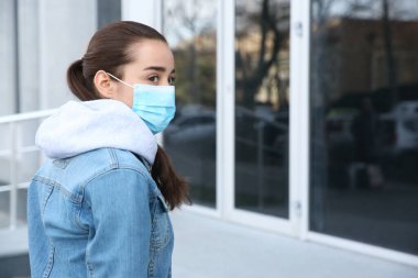 Açık havada tek kullanımlık maske takan bir kadın. Tehlikeli bir virüs.
