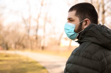 Açık havada tek kullanımlık maske takan bir adam. Tehlikeli bir virüs.