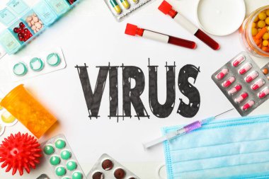 Beyaz zemin üzerinde VIRUS kelimesi ve ilaçlar bulunan düz kompozisyon