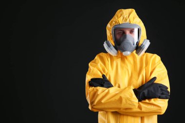 Man wearing chemical protective suit on black background, space for text. Virus research clipart