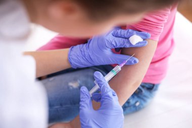Küçük kız klinikte suçiçeği aşısı oluyor, yakın plan. Varicella virüs önleme