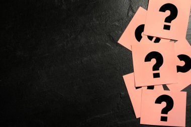 Siyah taş masada pembe kartlar ve soru işareti var. Metin için boşluk