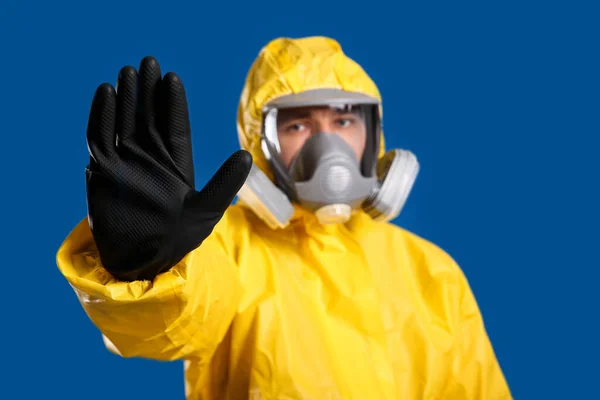 Άνθρωπος Χημική Προστατευτική Στολή Κάνει Στάση Χειρονομία Μπλε Φόντο Επικεντρωθεί — Φωτογραφία Αρχείου