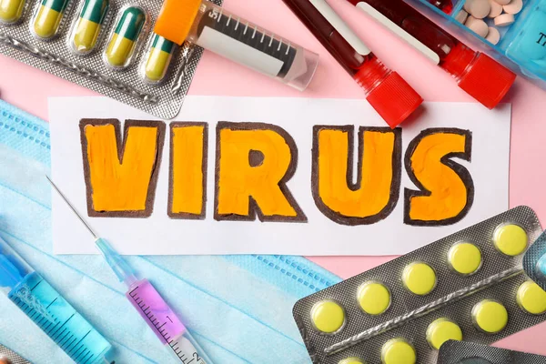 VIRUS sözcüğüyle düz kompozisyon ve pembe arka planda ilaçlar